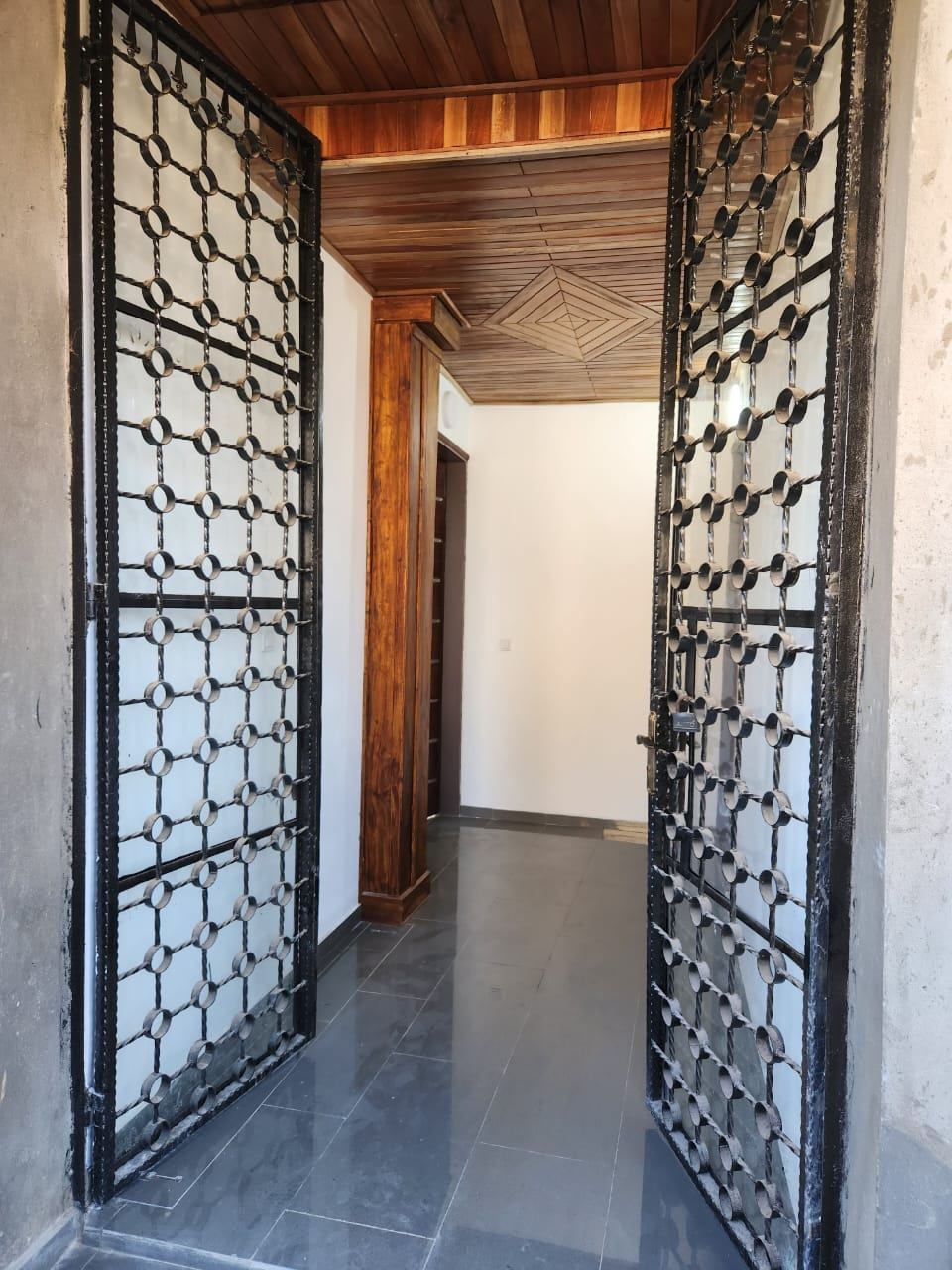 Entrée avec portes en fer forgé et plafond bois